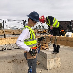 A student grabs a tool from his tool belt while working on a construction project for the Building and Construction CTE class.